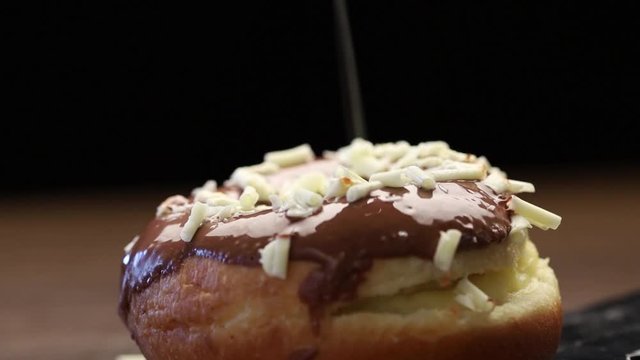 P&atilde;o doce com calda de chocolate e flocos de chocolate branco