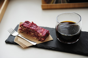 Served black coffee and dessert. Slate board, vegan cake Napoleon Millefeuille on a paper coffee filter