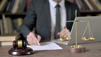 Close up Shoot of Judge Hand making Notes with Laptop in Court Room