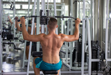 Fototapeta na wymiar young man lifting weights in gym