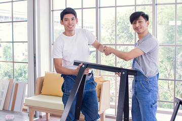 Men are hold hands after finishing project of handmade furniture