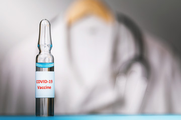 The vaccine from the new coronavirus COVID-19 on the background of a medical gown with copy space