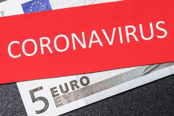 Five euros and a sheet with the inscription, close-up. The concept of the effect of coronavirus on the European currency