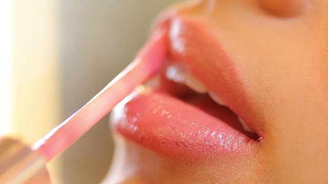 Passando batom cor de rosa nos l&aacute;bios