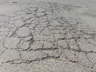 Close up of old cracked asphalt. Urban road with damaged asphalt, texture, backgroud.	