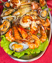 A large dish of seafood, octopus, scallops, mussels, fried fish