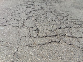 Close up of old cracked asphalt. Urban road with damaged asphalt, texture, backgroud.