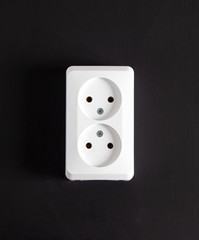 White socket with two connectors on a black background.