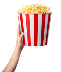 Woman hand holding striped bucket with popcorn isolated on white background