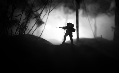 Army sniper with large caliber rifle standing in the fire and smoke. War Concept. Battle scene on...