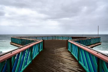 Fotobehang Old wooden observation platform at cloudy seaside © Stefan