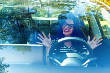 Woman in a self-driving autonomous electric vehicle with hands off the steering wheel