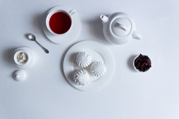 Marshmallow on  plate with hibiscus tea cup on white background