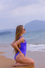 Fototapeta na wymiar Beautiful slim girl in a blue swimsuit on the ocean.