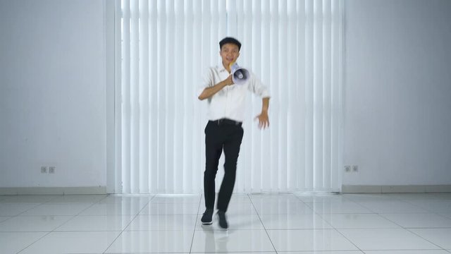 Businessman dances and shouts with megaphone