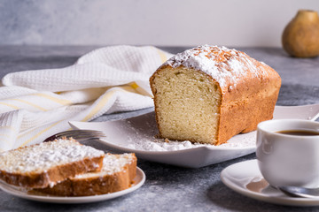 Morning tea concept. Cake and a Cup of tea on a table, pears on blurred bokeh background.