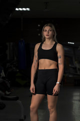 Fototapeta na wymiar Portrait of a sportswoman with blond hair in a sports uniform in a fitness gym.