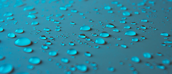 Many different drops of water rain on a blue background