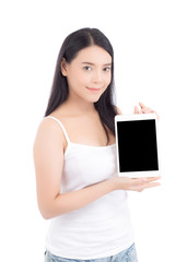 Fototapeta premium Portrait of asian young woman standing showing blank screen tablet isolated on white background, girl showing technology, business and communication concept.