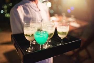 waitress carry welcome soft drink in nightclub.