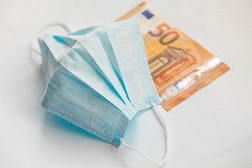 Virus protection mask against pandemic of coronavirus COVID-19. Dirty money banknote.