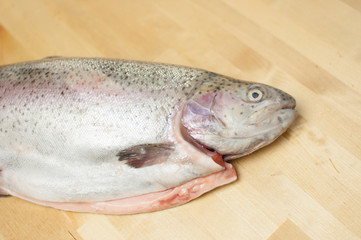 Cutting gutted red fish trout sweetfish on wood background