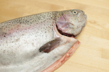 Cutting gutted red fish trout sweetfish on wood background