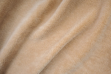 Beautiful beige color. Soft fleece fabric. The  material is carelessly folded and wrinkled on a...