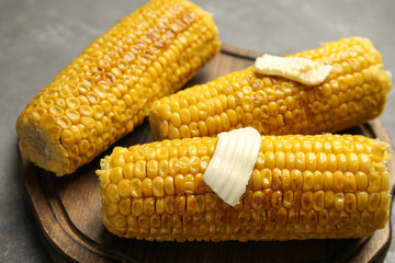 Delicious grilled corn with butter on table, closeup
