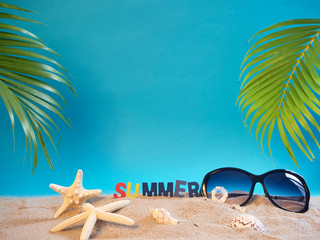 Fototapeta na wymiar Sunglasses on beach with blue background.