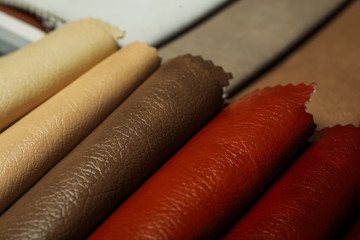 Different leather samples as background, closeup view