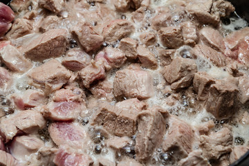 Fried meat in a frying pan closeup. Top view 