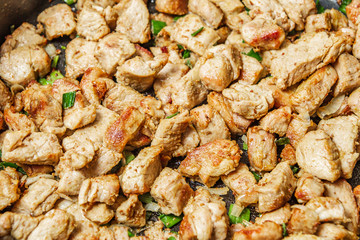 Fried meat in a frying pan closeup. Top view 