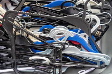 An untidy pile of plastic coat hangers