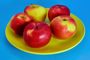 Ripe red red apples close-up isolate on a blue background.