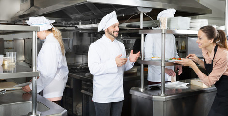 Chef checking dishes in kitchen of restaurant