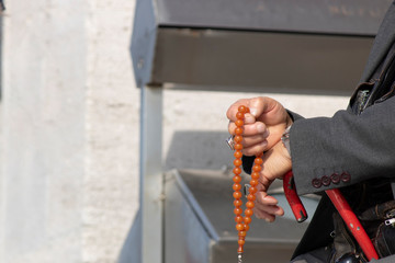 Close up of man's hand pulling the rosary. Close up.