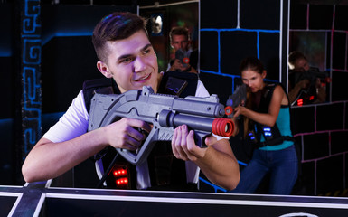 Fototapeta na wymiar guy holding laser pistol playing laser tag game