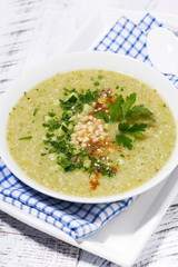 cold green gazpacho in a bowl, vertical top view