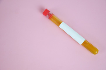 Colored liquids yellow in test tubes over pink background