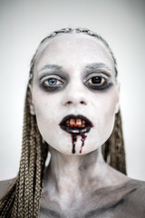 A girl with blood from her mouth looks at the camera
