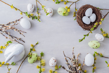 Flat lay easter composition with a willow branch and eggs on a gray background