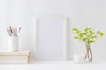 Home interior with decor elements. Mockup with a white frame, spring flowers in a vase on a light background