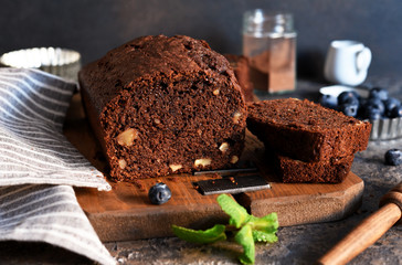 Chocolate cake with nuts and peel on a kitchen table.