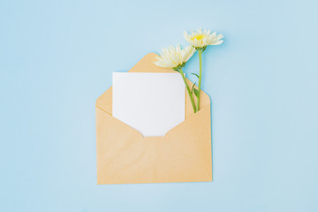 Mockup white greeting card  and envelope with flowers on a blue background