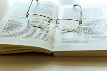 occhiali appoggiati sul libro aperto