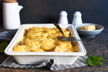 Casserole with potatoes, mushrooms and cheese on the kitchen table. Horizontal focus.