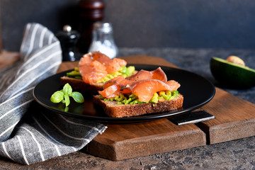 Sandwich with avocado and salmon for breakfast on the kitchen table.