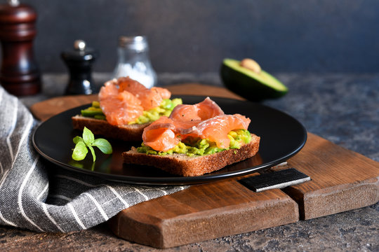Sandwich with avocado and salmon for breakfast on the kitchen table.