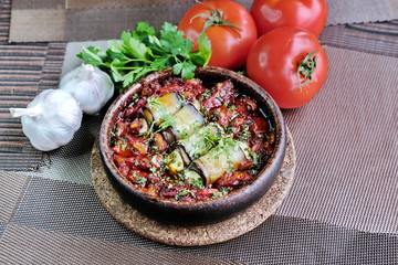 The food is Georgian cuisine.Eggplant slices are rolled into rolls with Suluguni cheese and baked with vegetables in tomato sauce